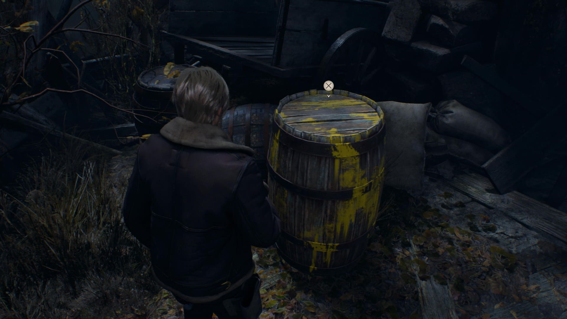 A Resident Evil 4 screenshot showing the protagonist standing next to a wooden barrel painted with streaks of yellow, an interaction prompt floating above it.